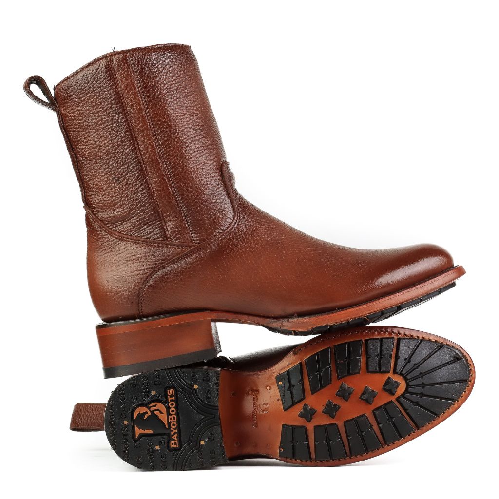 Bota en posición invertida mostrando la suela con injertos de goma.