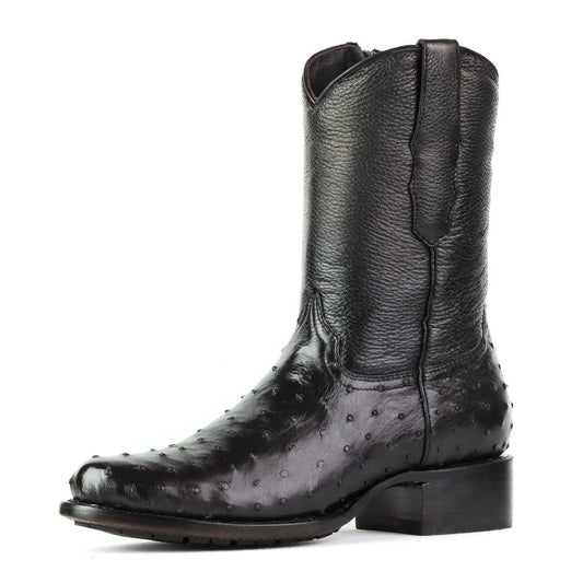 Vista lateral de la bota negra mostrando su textura de piel exótica.